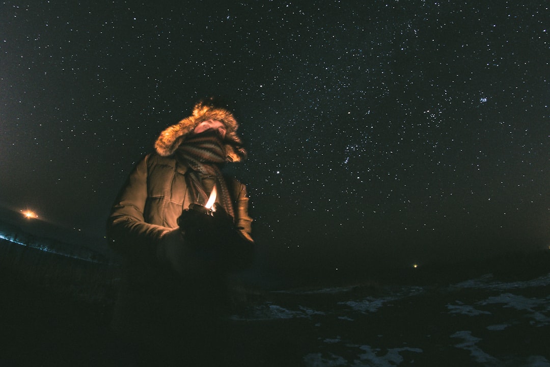 woman in black jacket standing under starry night