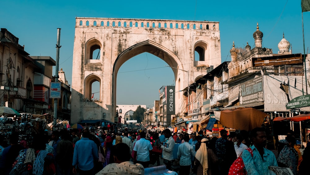 people standing near white concrete arch during daytime