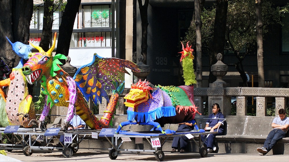 woman in pink yellow and green floral dress sitting on blue and white wheelchair during daytime