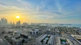 A panoramic shot of a luxury waterfront residential complex in Dubai at sunset.