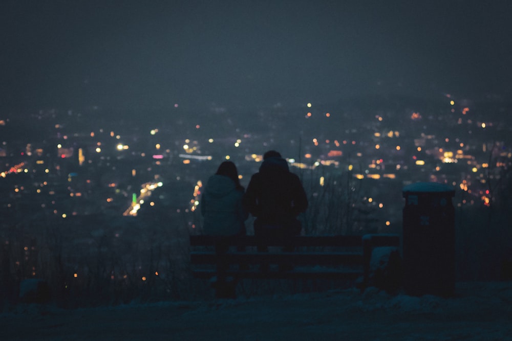 2 person standing on top of building during night time