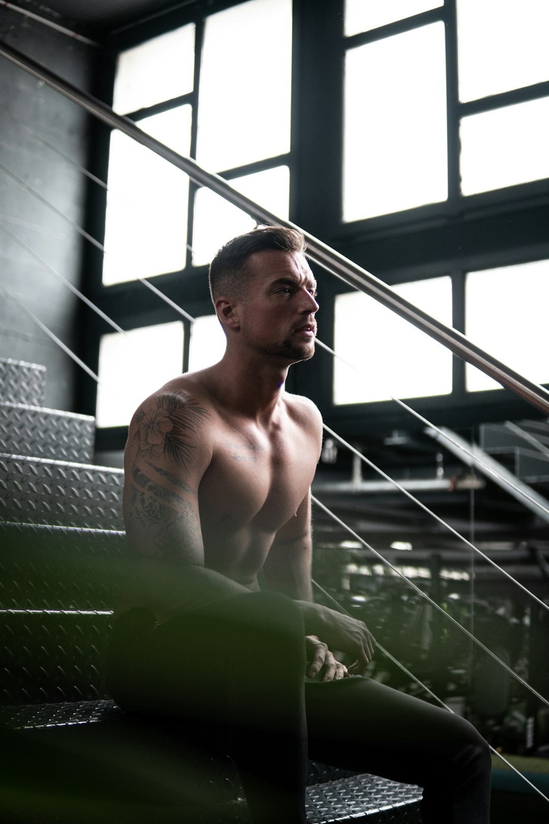 topless man sitting on green chair