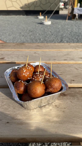 Happy customers enjoying biteballs outdoors on a sunny day.