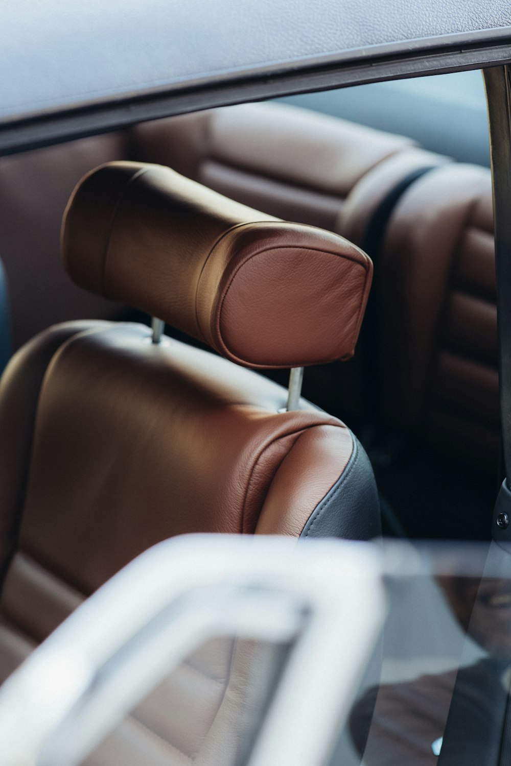 brown leather car seat with white textile