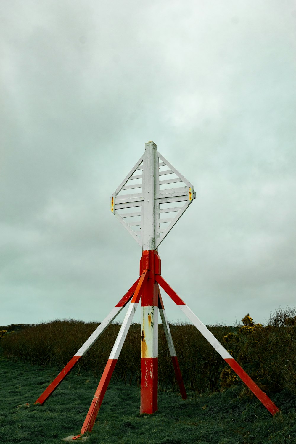 white and red metal tower under cloudy sky