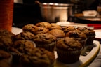 Freshly baked muffins cooling on a kitchen counter with natural light.
