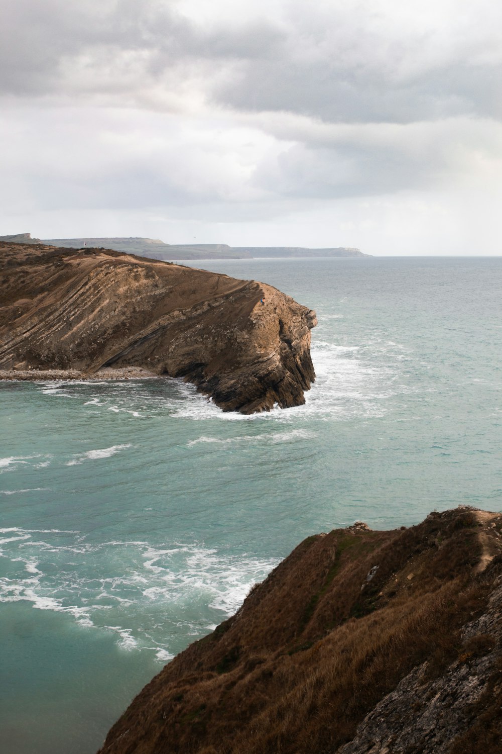 brown rock formation beside sea during daytime