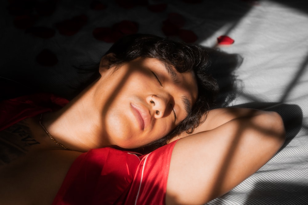 woman in red and white tank top lying on bed