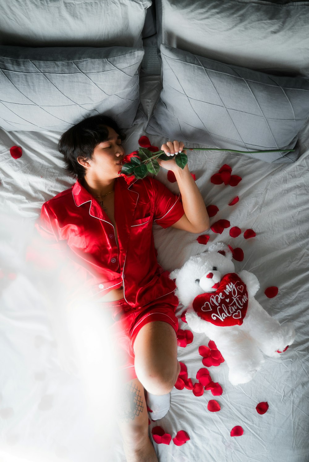 ベッドに横たわる赤いシャツの女性