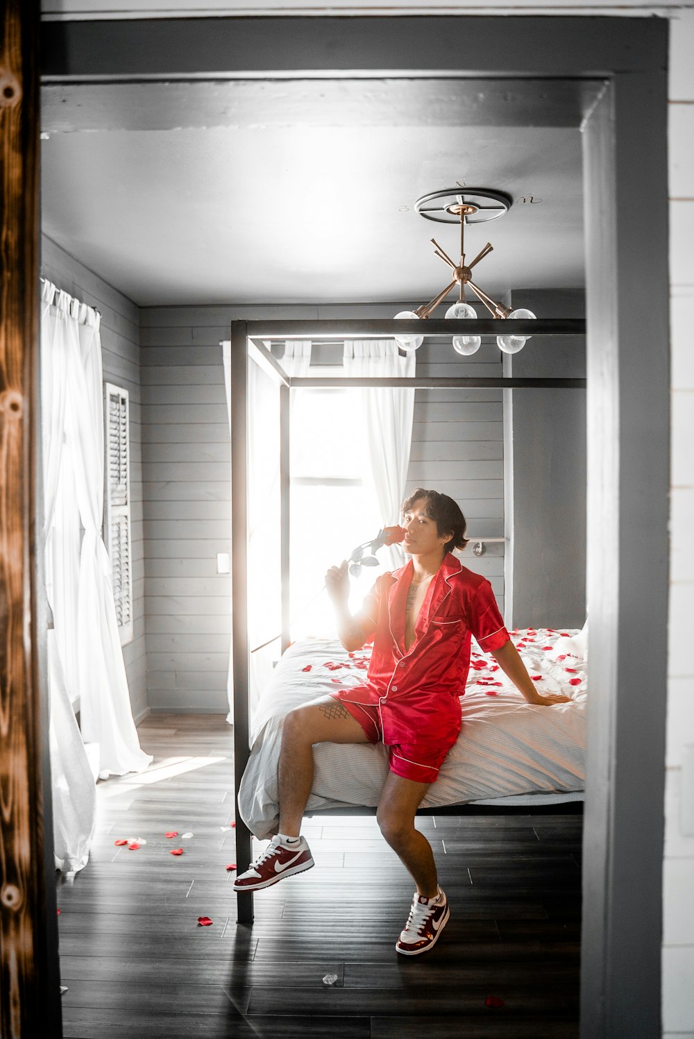 man in red t-shirt sitting on bed