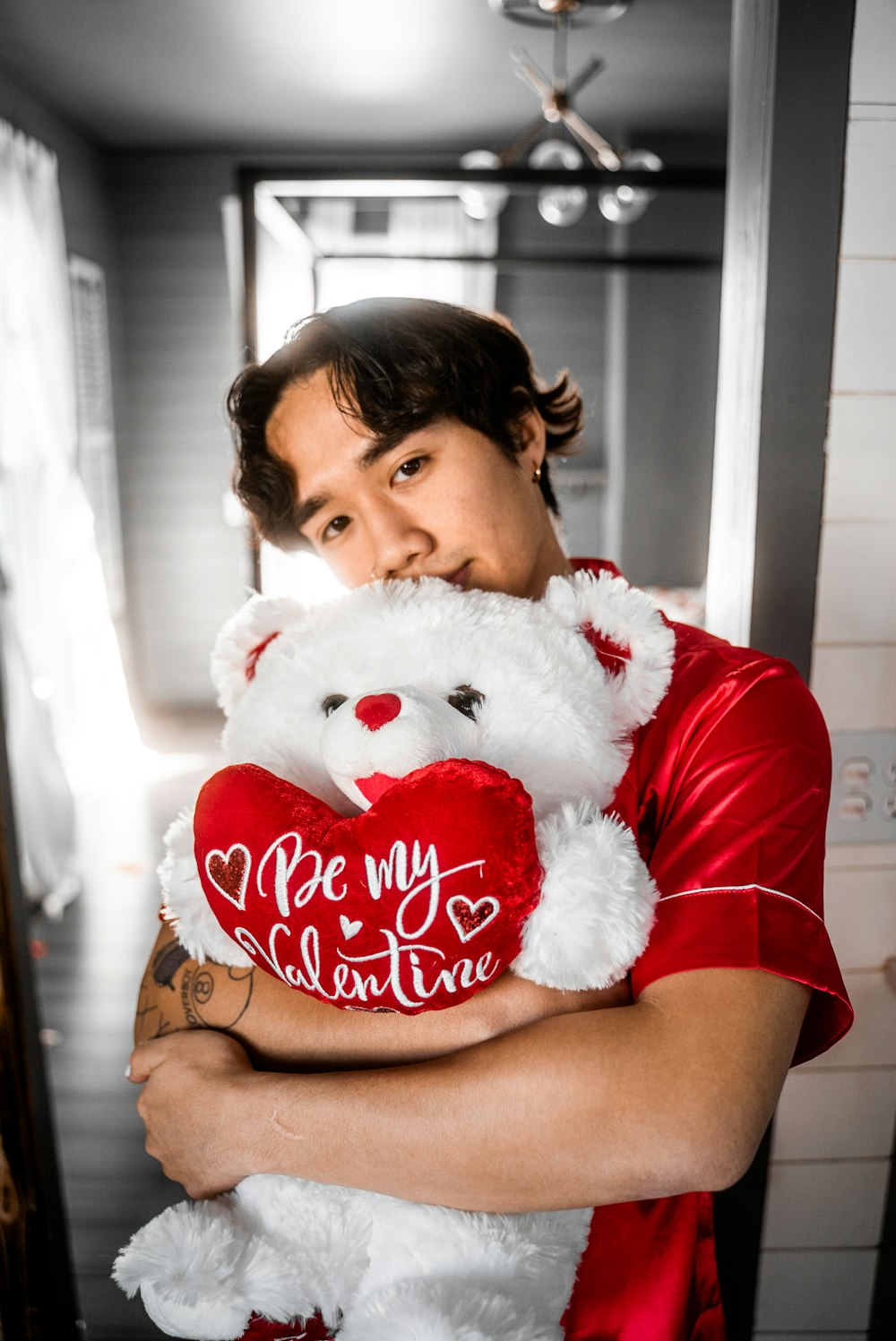 girl in red t-shirt holding white bear plush toy