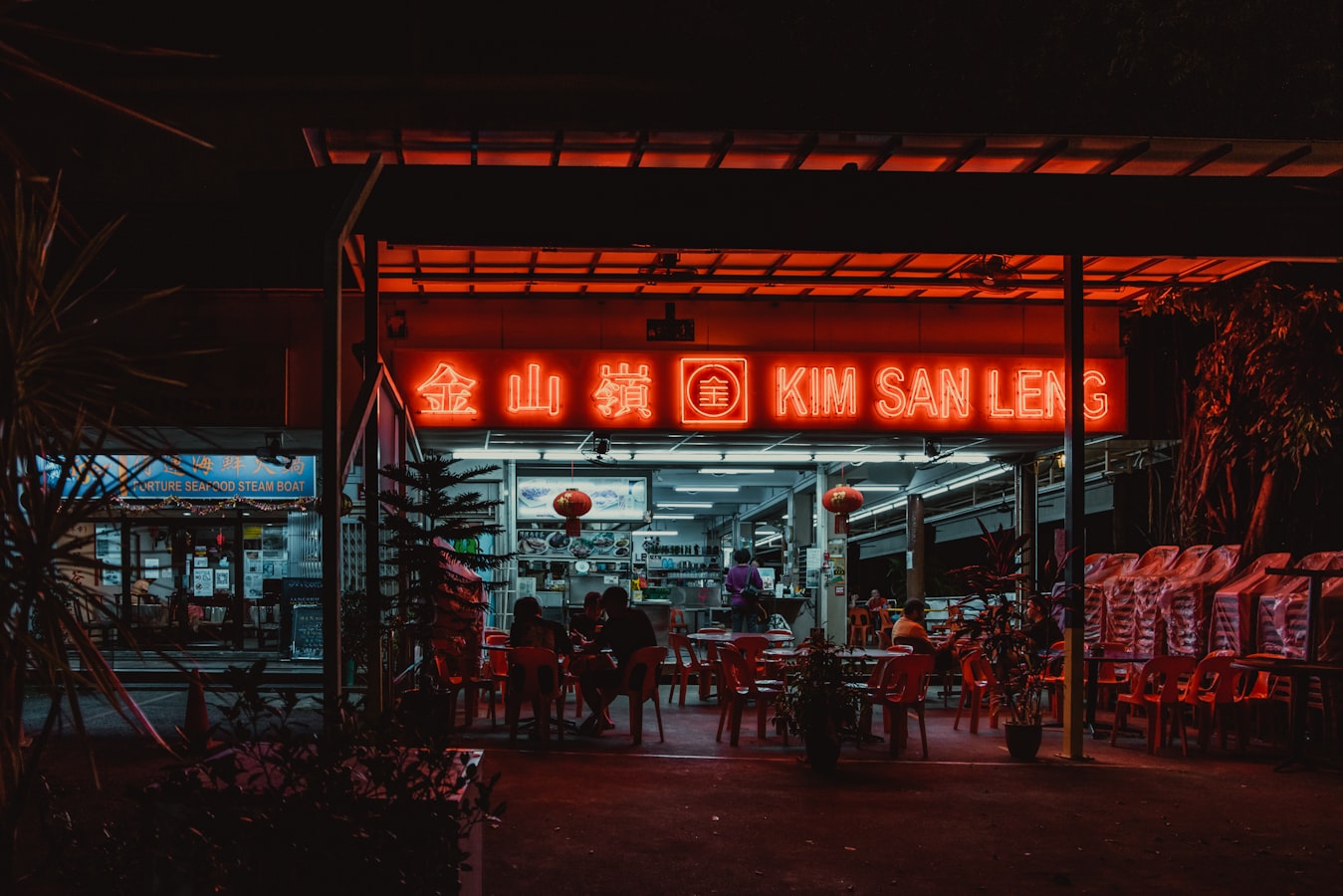 A Southeast Asian night-market hawker scene at dinner service