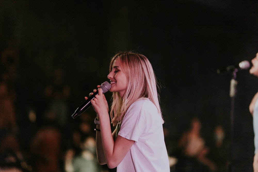 woman in white t-shirt singing