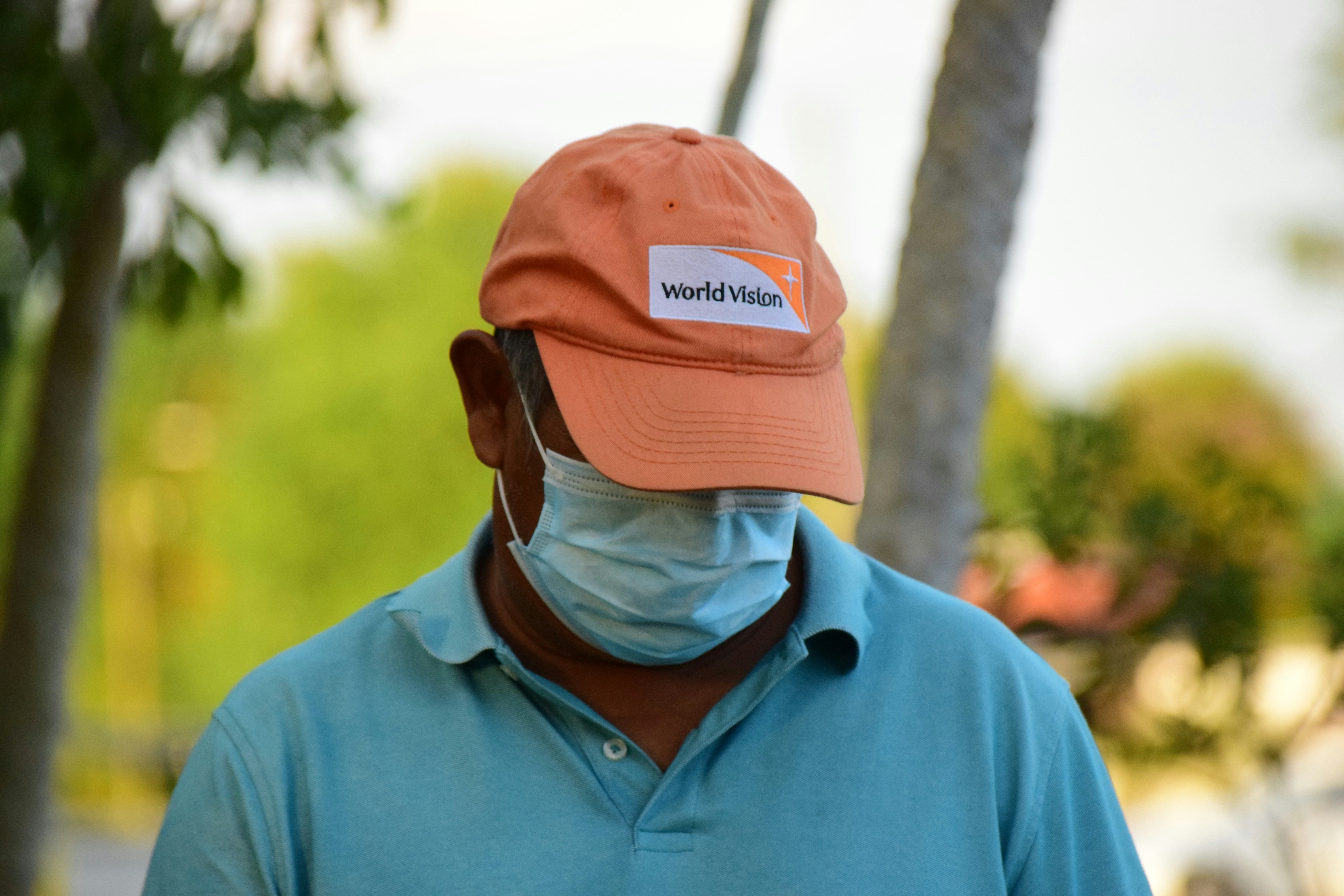 man in blue polo shirt wearing orange knit cap