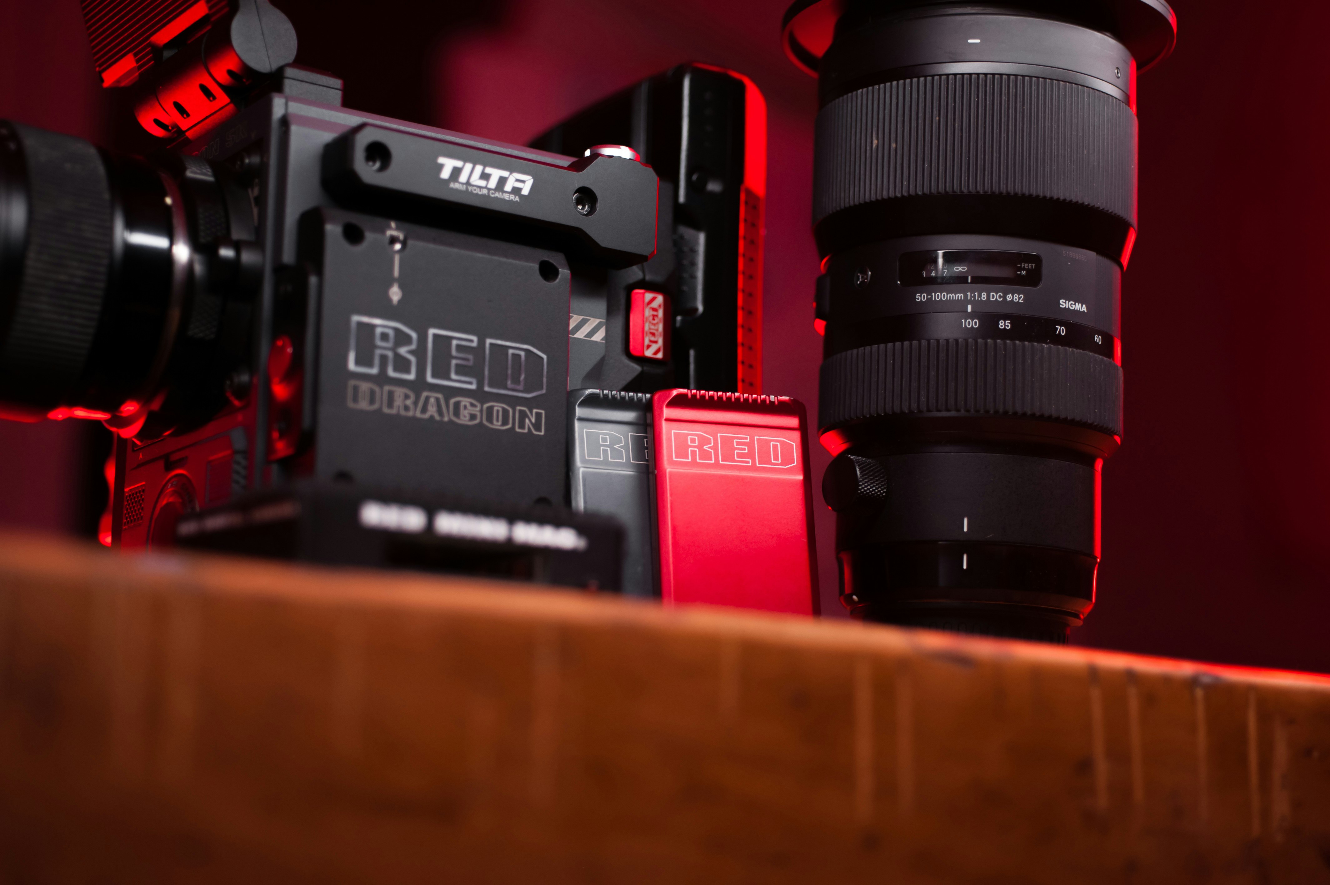 black and red dslr camera on brown wooden table