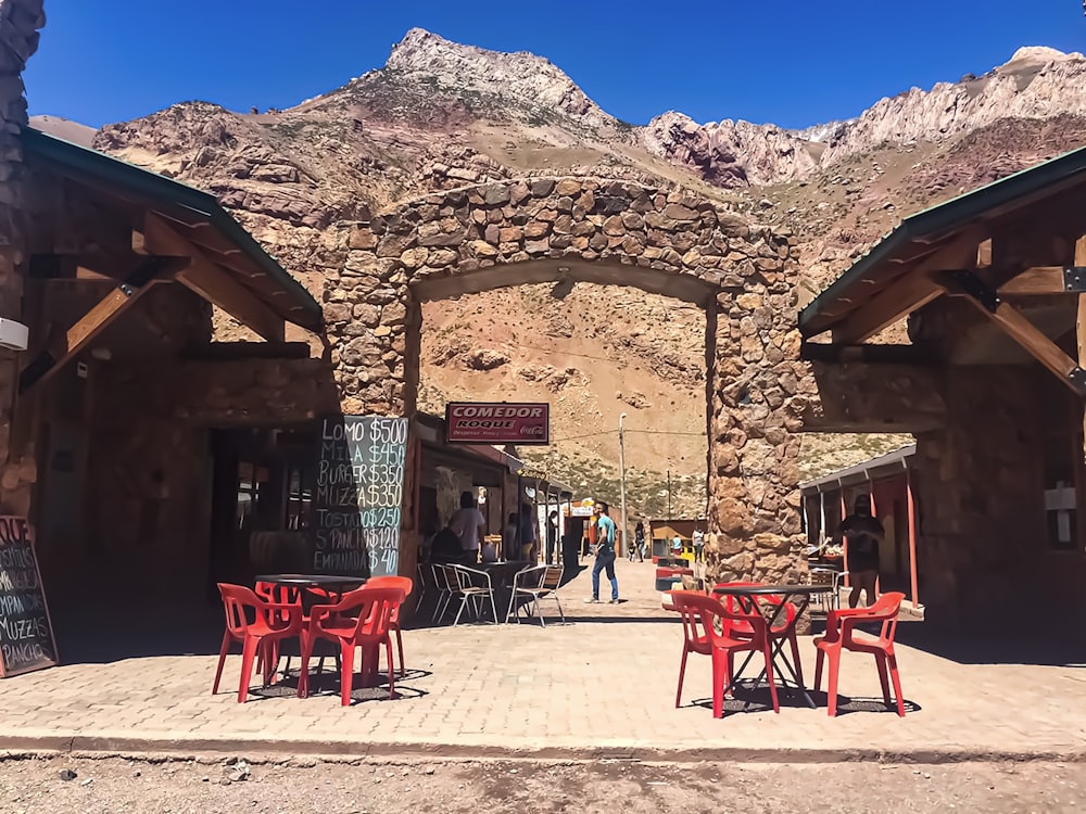 red plastic chairs and tables near brown concrete building during daytime