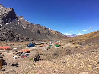 people on brown field near mountain under blue sky during daytime
