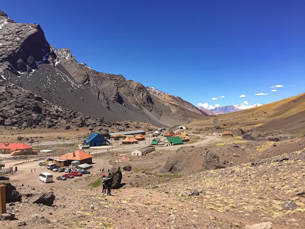 people on brown field near mountain under blue sky during daytime