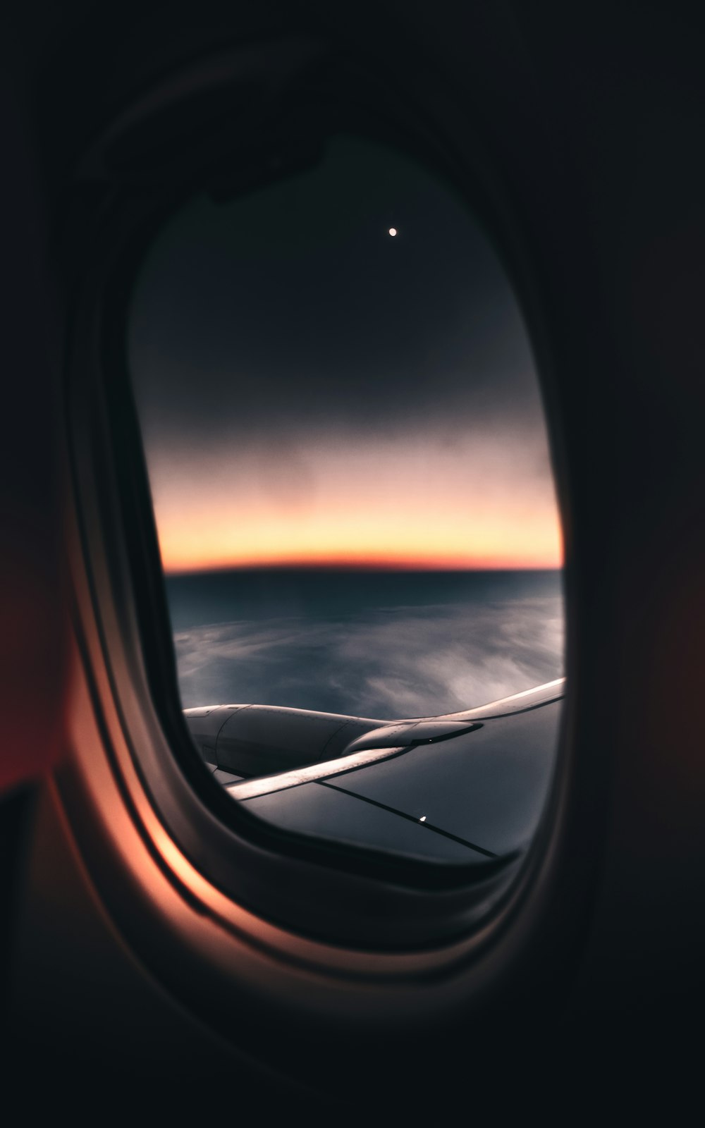 Vista de la ventana del avión de las nubes durante la puesta del sol