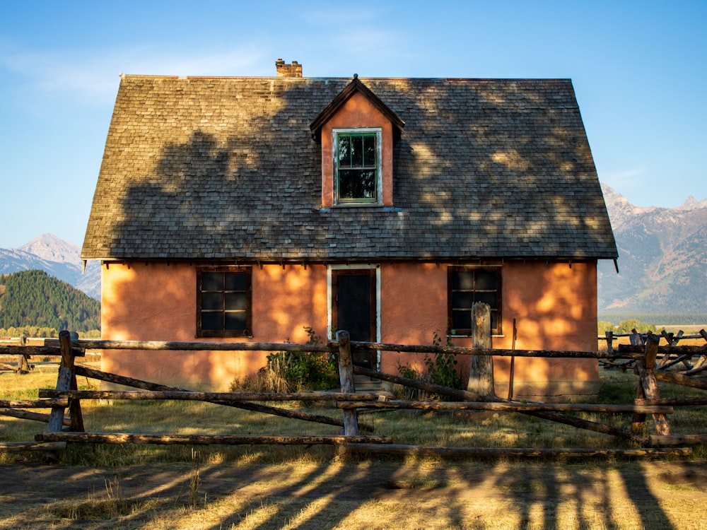 brown brick house near green grass field during daytime