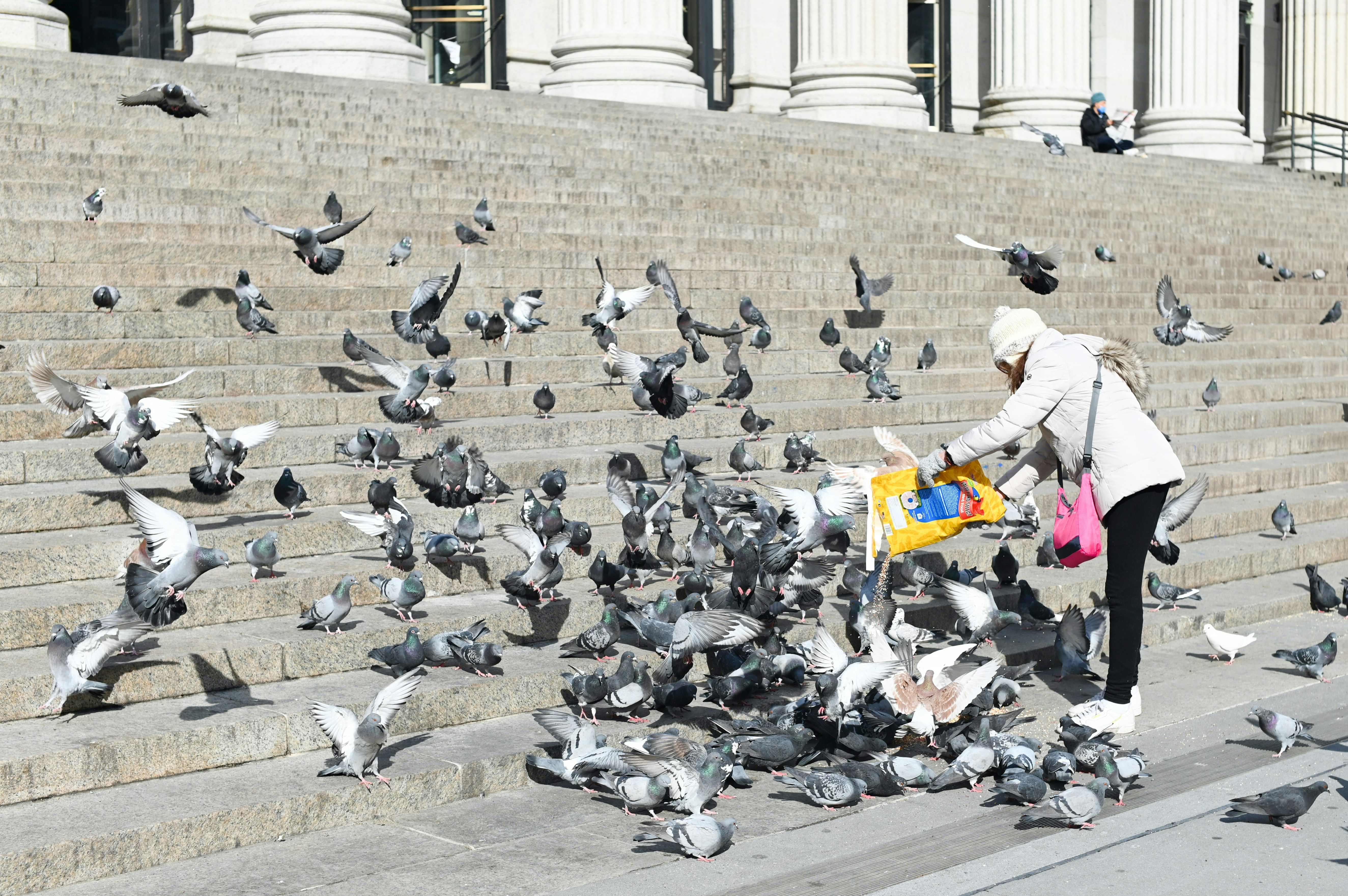 man in white and yellow jacket and yellow pants standing on gray concrete floor during daytime