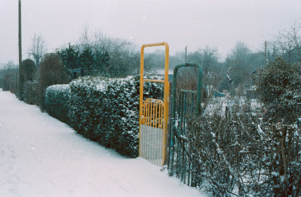 brown metal fence covered with snow