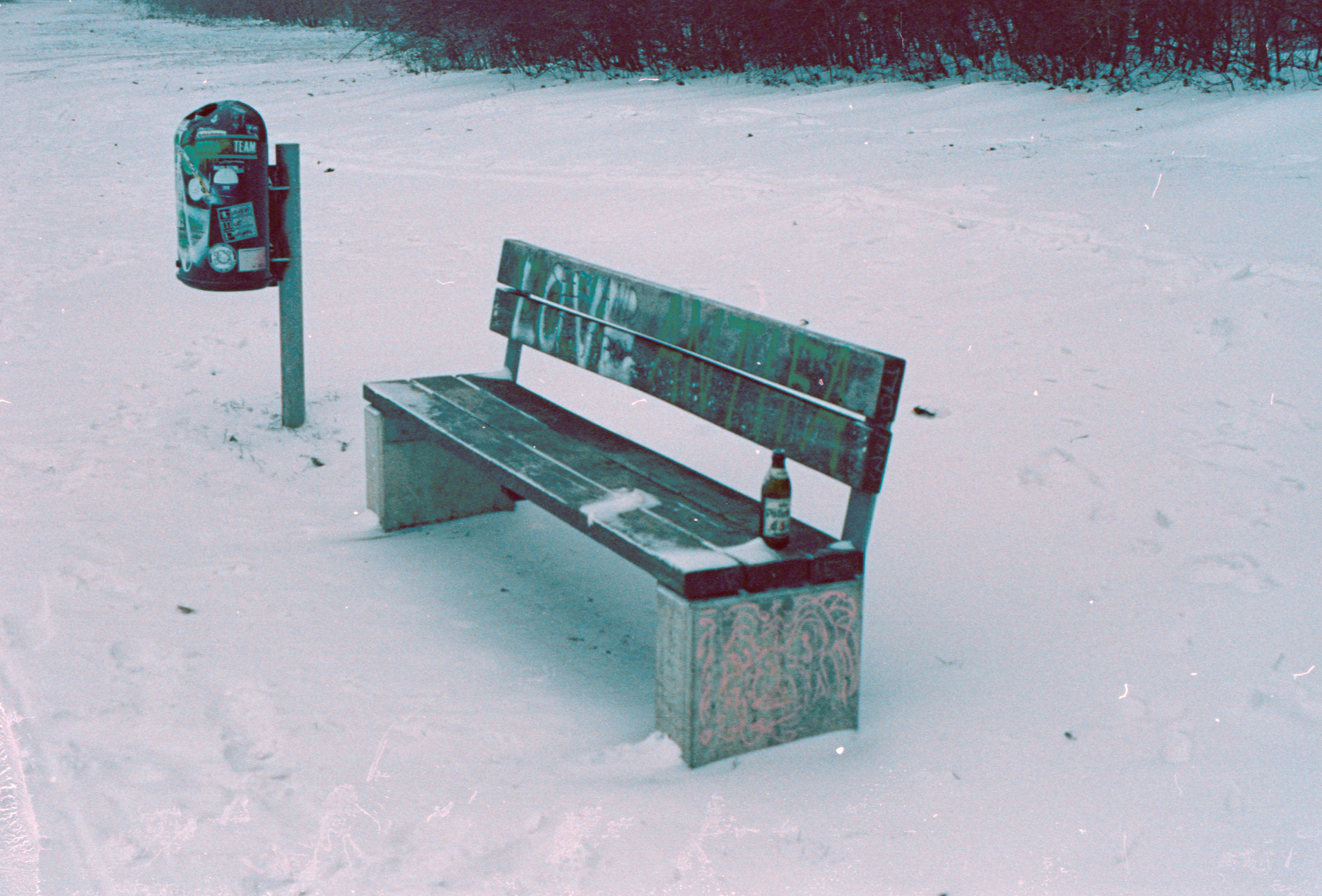 rote Holzbank auf schneebedecktem Boden