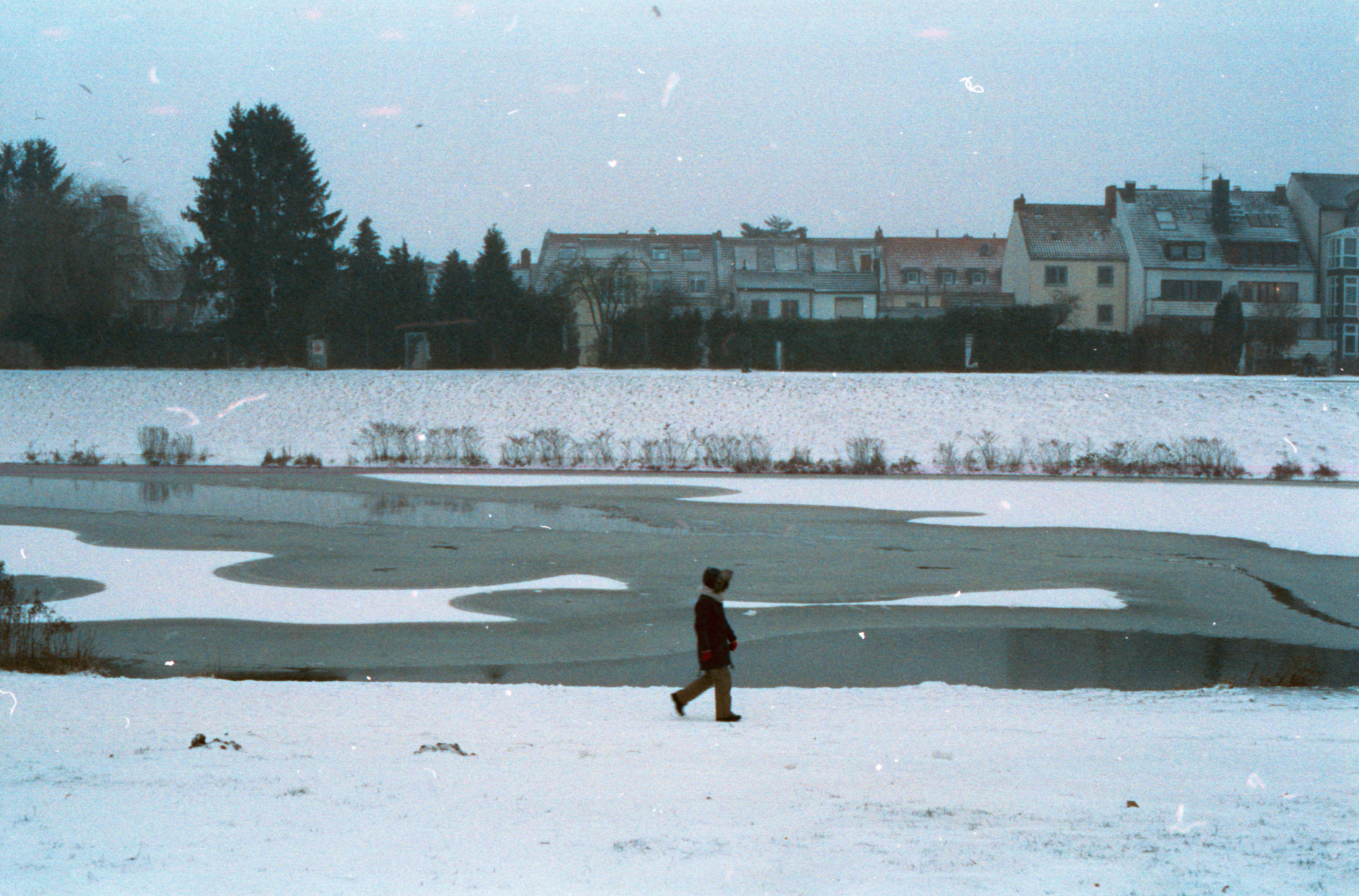 woman in black shirt and yellow skirt walking on snow covered ground during daytime