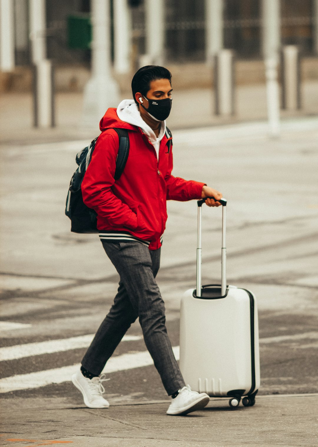 man in red jacket and black pants wearing white mask