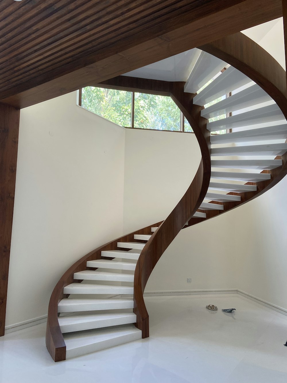 brown wooden spiral staircase on white painted wall