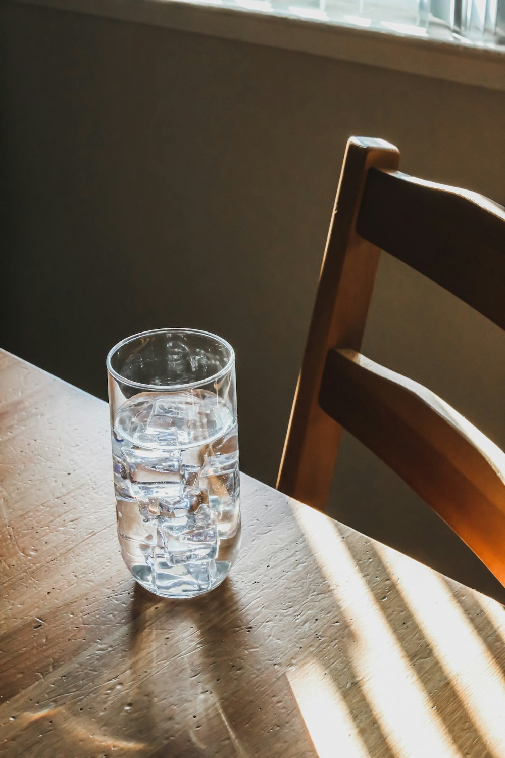 茶色の木製テーブルの上の透明なコップ