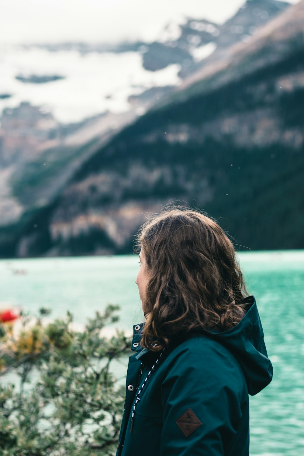 woman in green hoodie looking at the lake