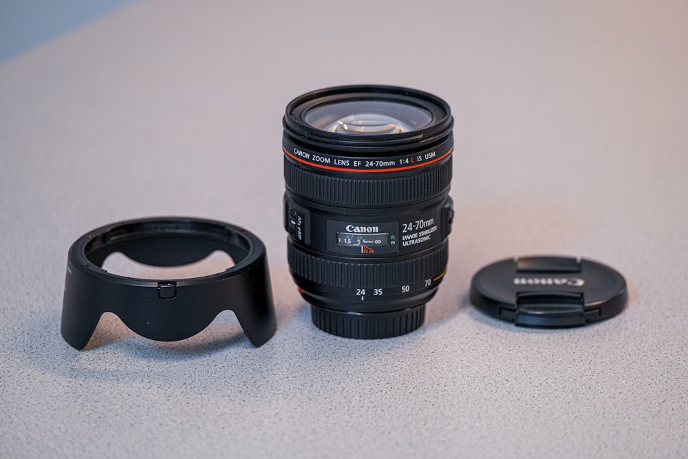 black nikon camera lens on white table