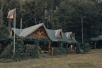 brown wooden house near green trees during daytime
