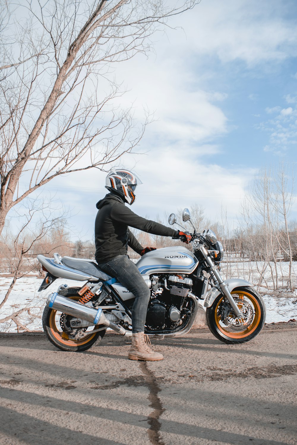 man in black jacket riding on black and orange sports bike