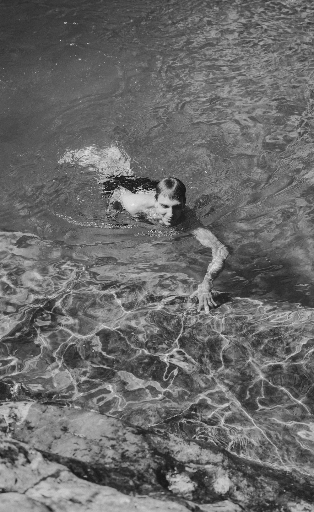 grayscale photo of man surfing on water