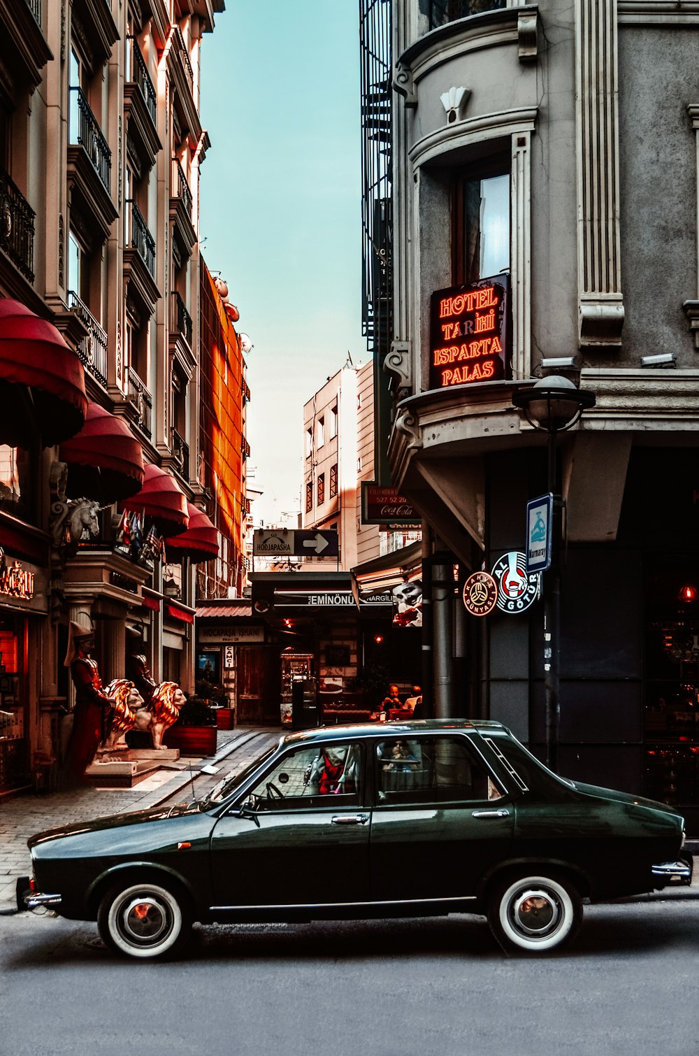 black sedan parked beside red umbrella during daytime