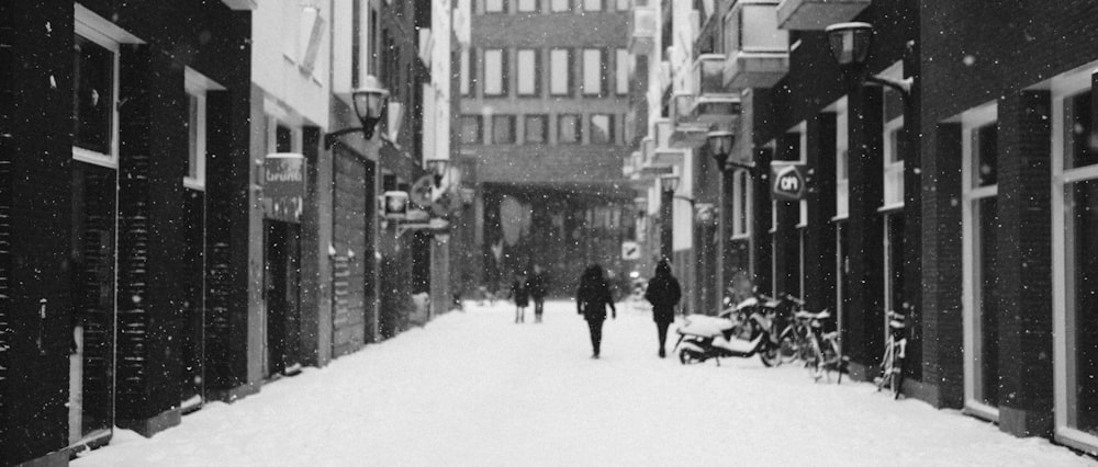 昼間、ビルの近くの雪道を歩く人々