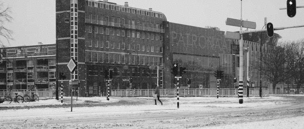 grayscale photo of people walking on street near building