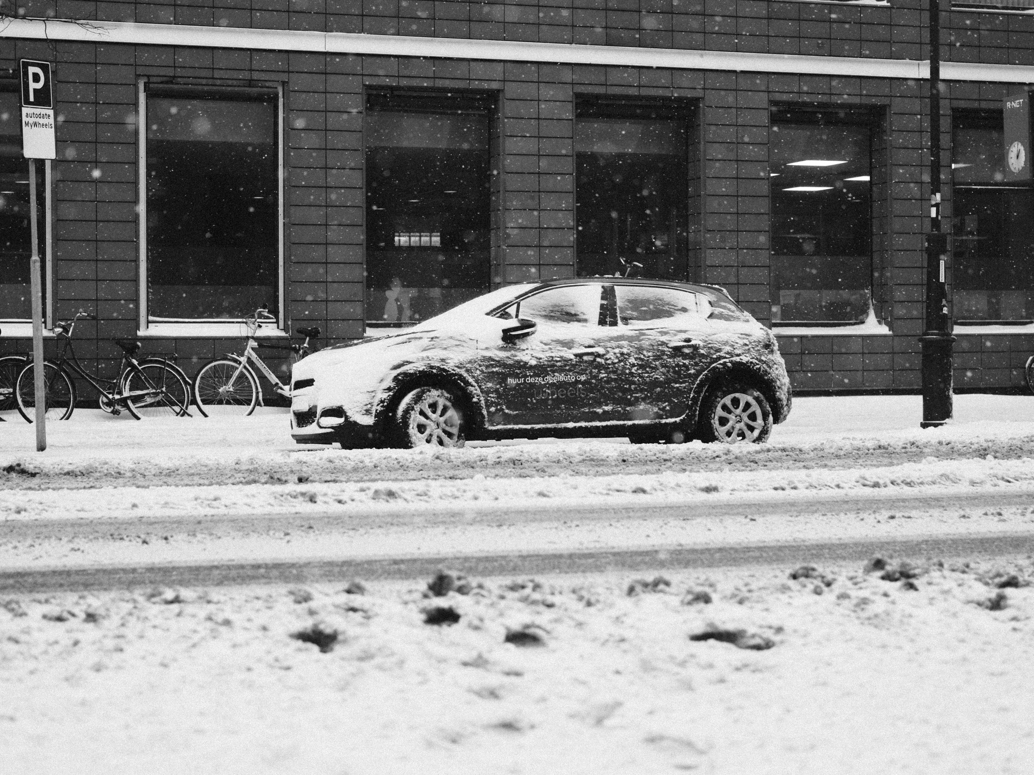 grayscale photo of car parked on street
