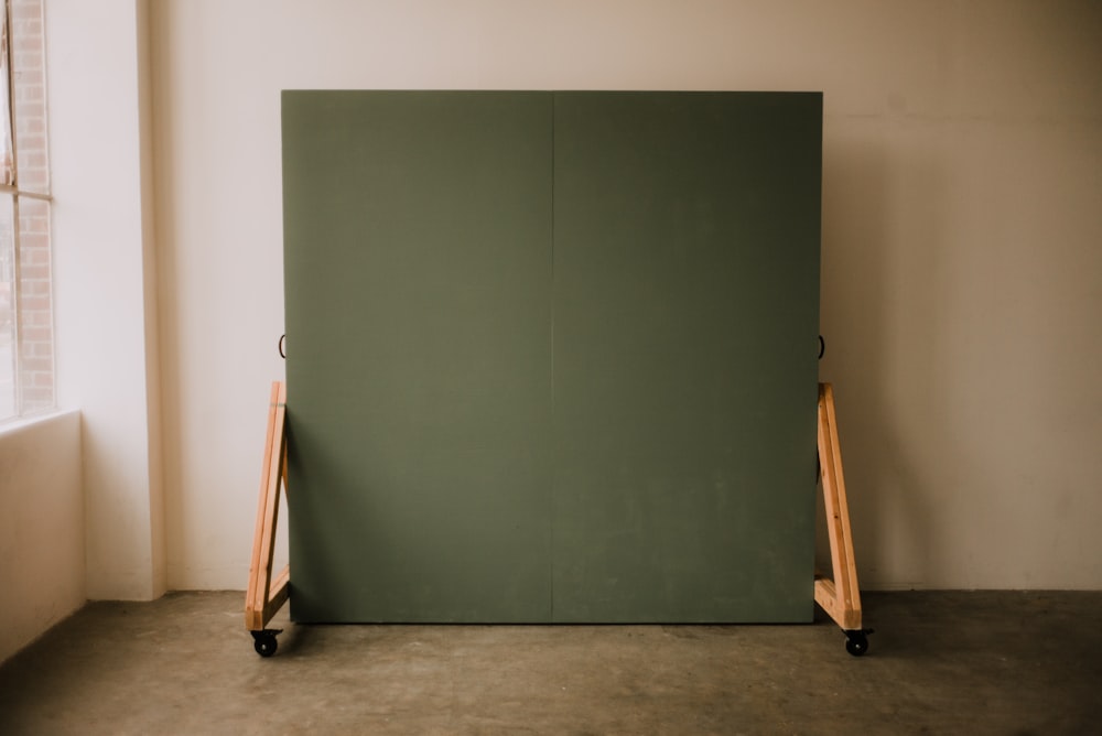 brown wooden stick leaning on green wall