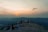 A group of travelers enjoying a scenic view atop a mountain during sunset.
