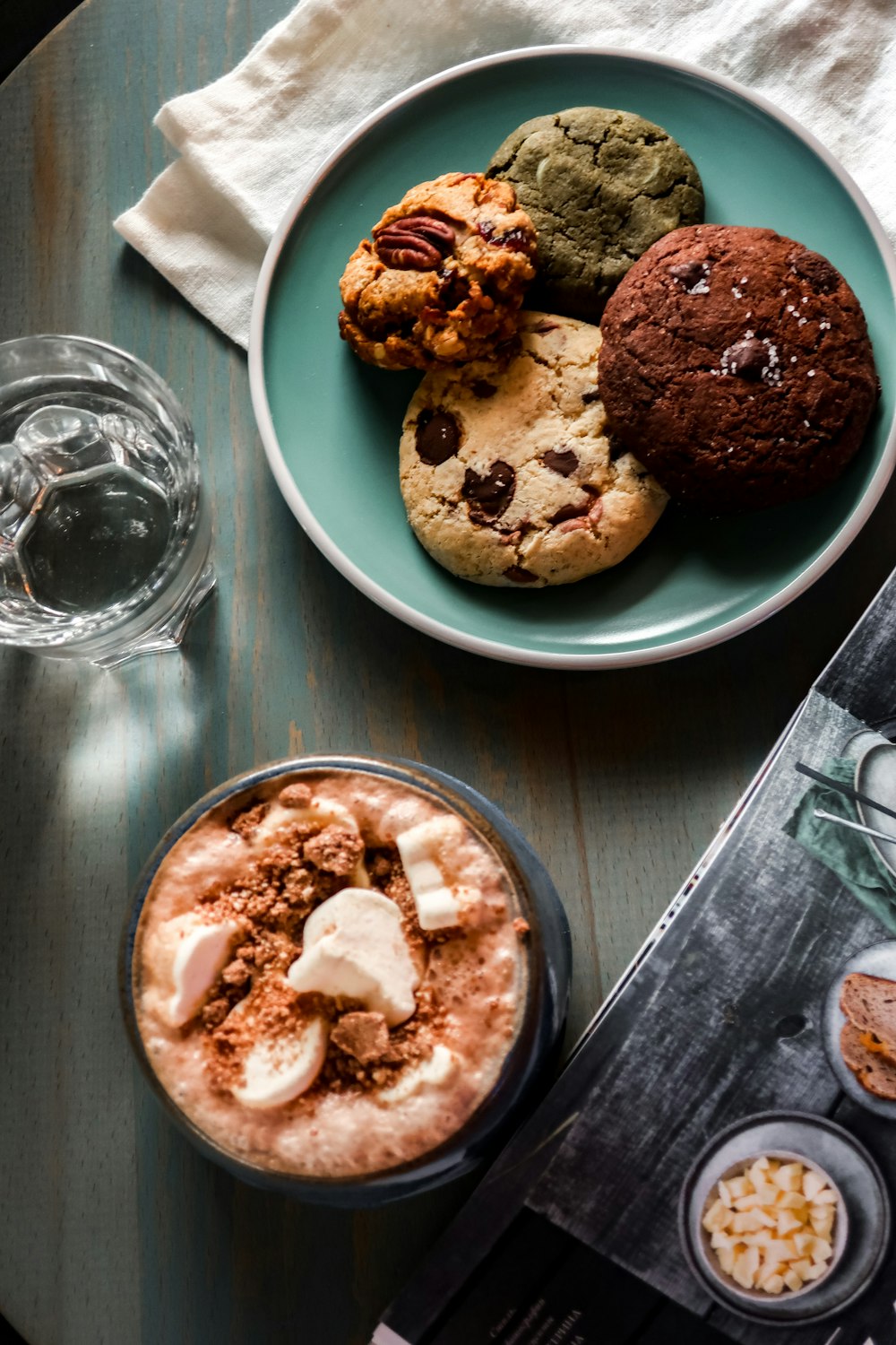 chocolate chip cookies on white ceramic plate beside clear drinking glass