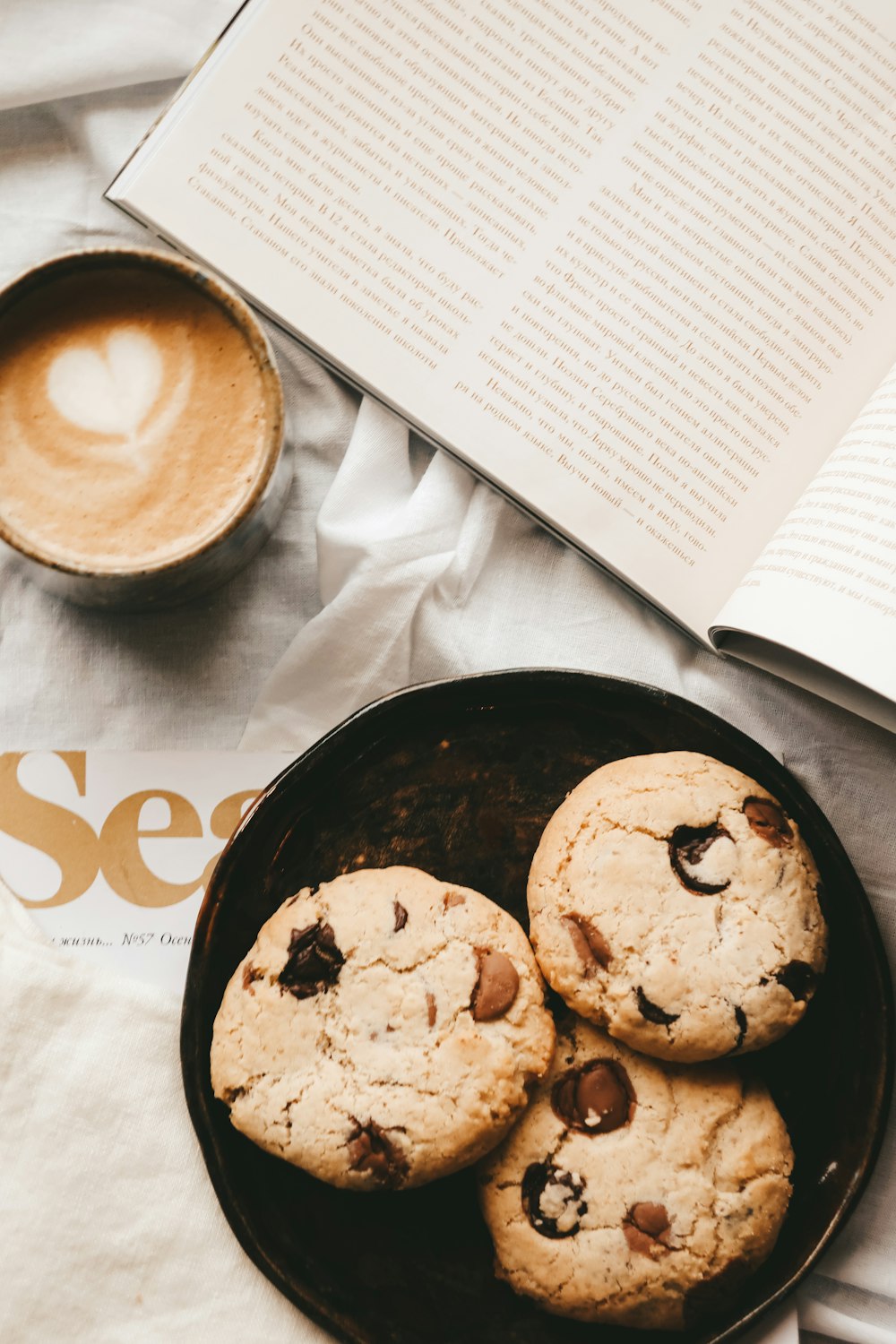 cookies on black ceramic plate beside white ceramic mug with coffee