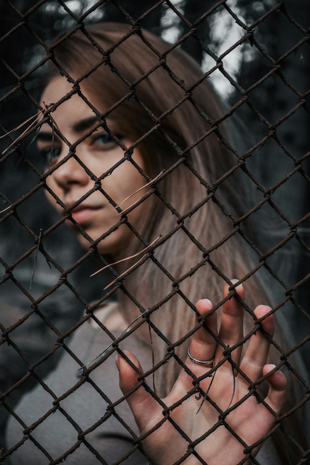 woman behind black metal fence