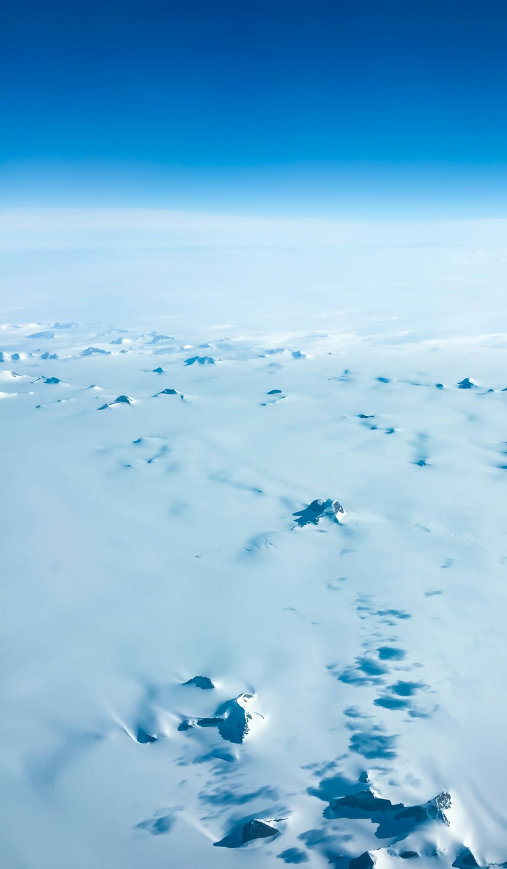 white snow covered field under blue sky during daytime