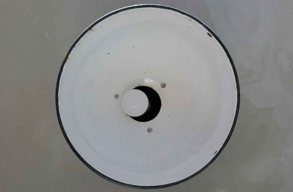white round plastic container on white textile