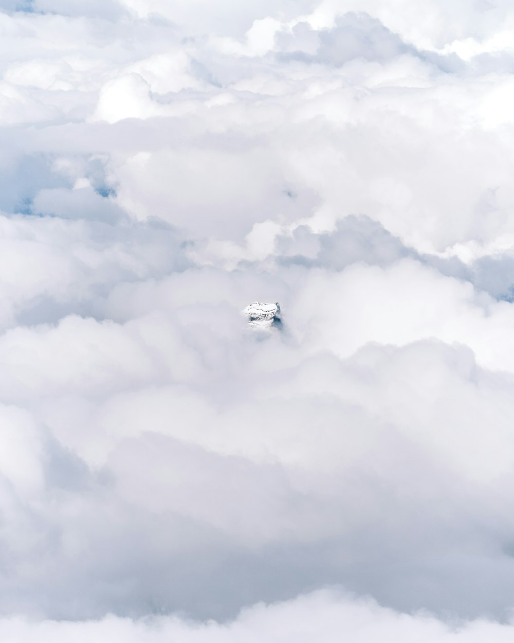 white airplane on mid air under white clouds during daytime