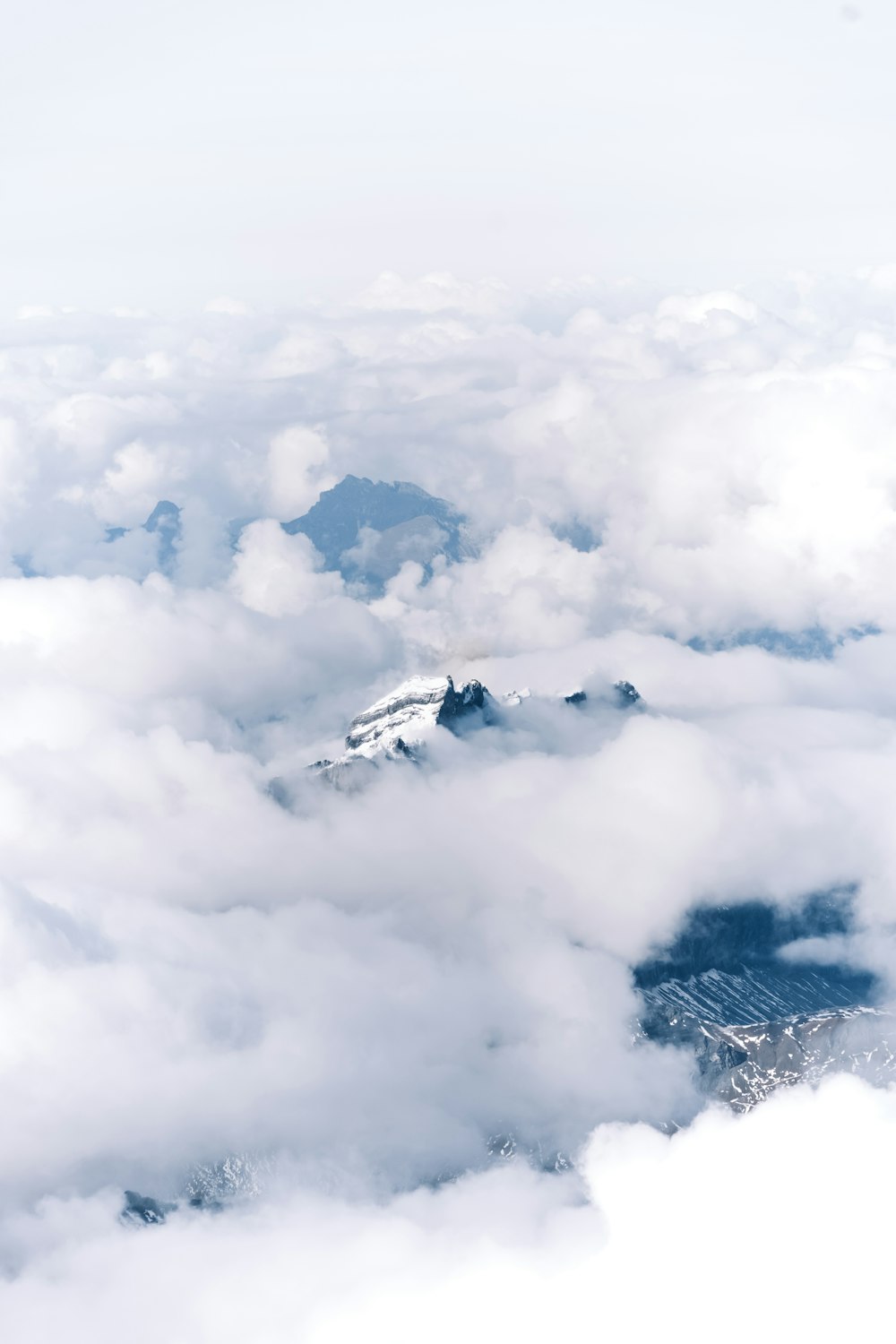 white clouds over snow covered mountains