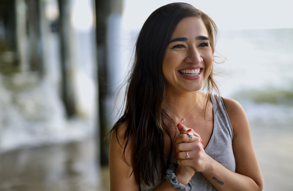 Mujer sonriente en camiseta sin mangas gris